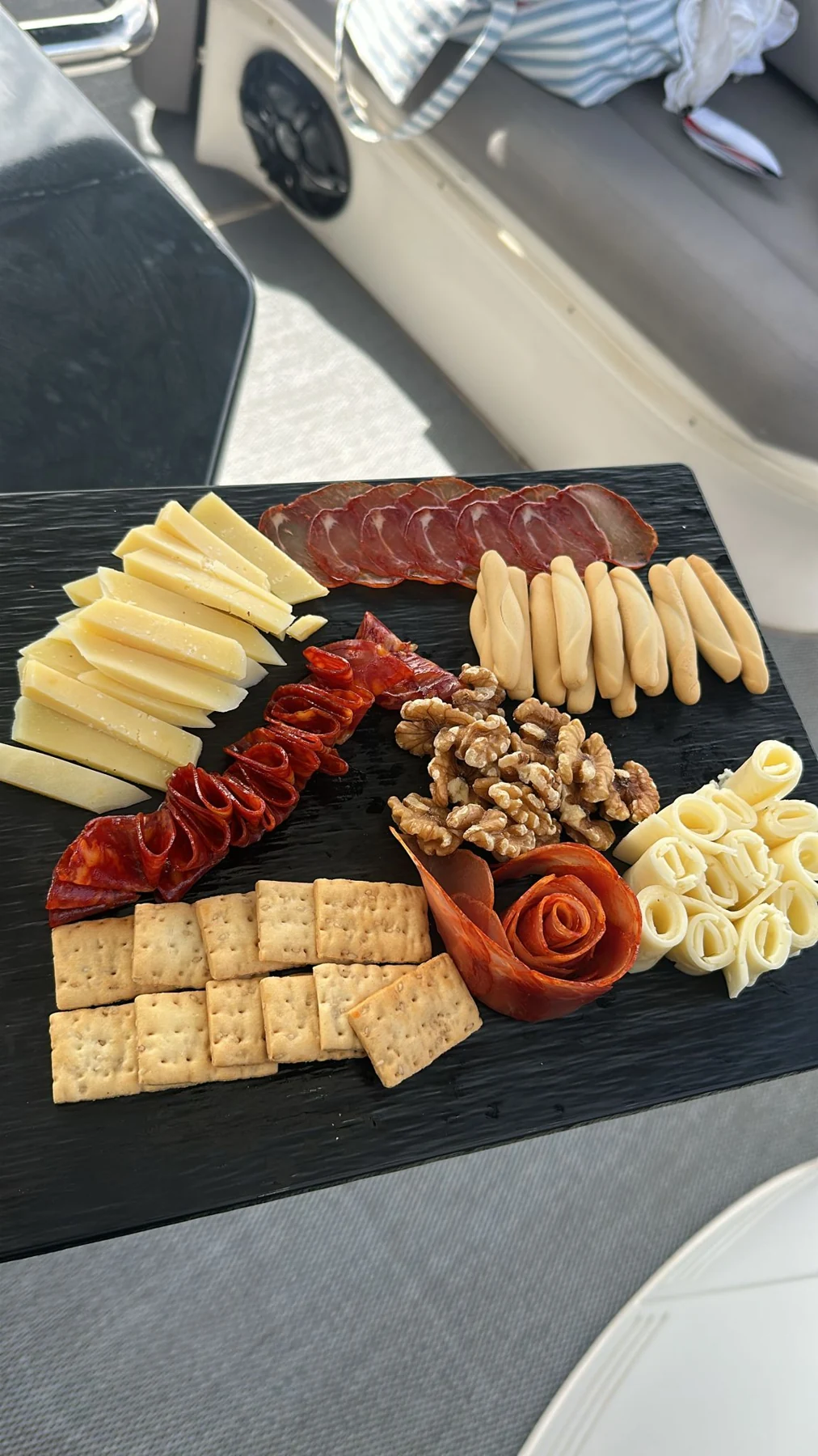 An Bord angerichtete Platte mit Käse, Wurst, Nüssen und Snacks