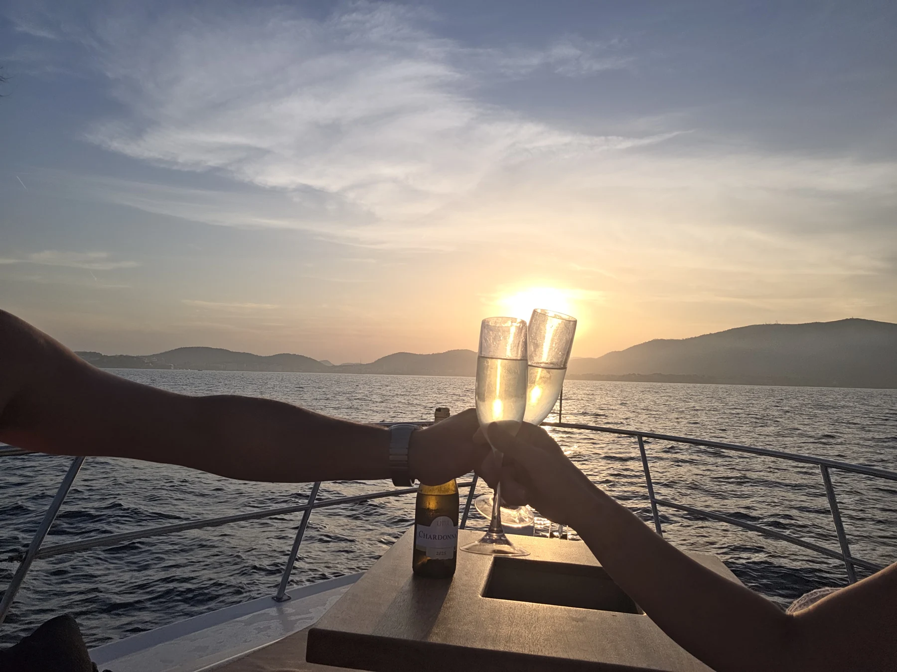 Zwei Menschen stoßen vor dem Sonnenuntergang an