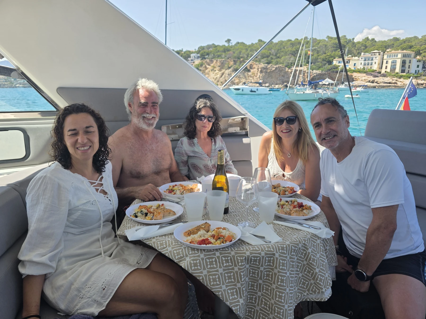 Fünf Menschen genießen gemeinsam ein Essen und lächeln am Tisch